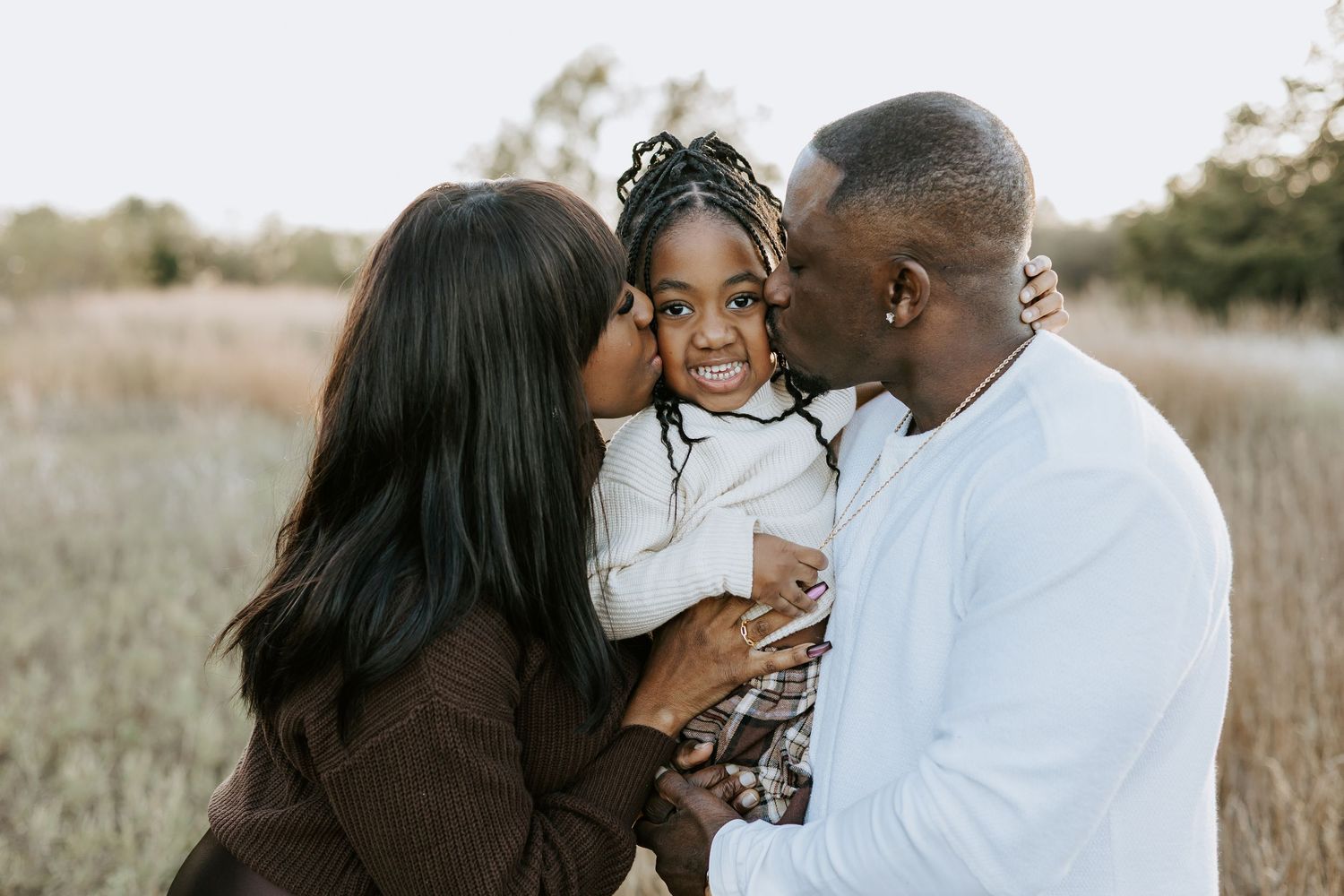 Sweet family moments captured during sunset in a natural outdoor setting.