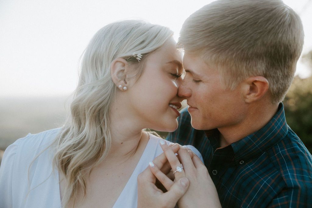 Couple sharing intimate moments in bright, airy setting with soft natural light.