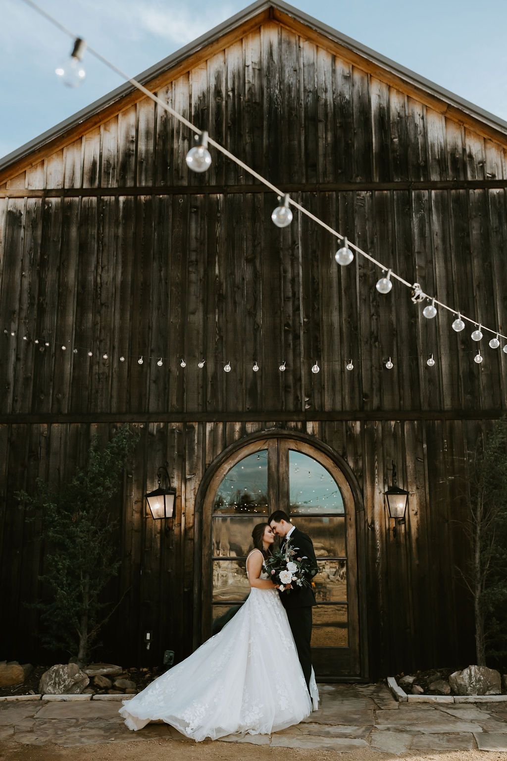 Rustic barn wedding venue with string lights and romantic evening atmosphere.