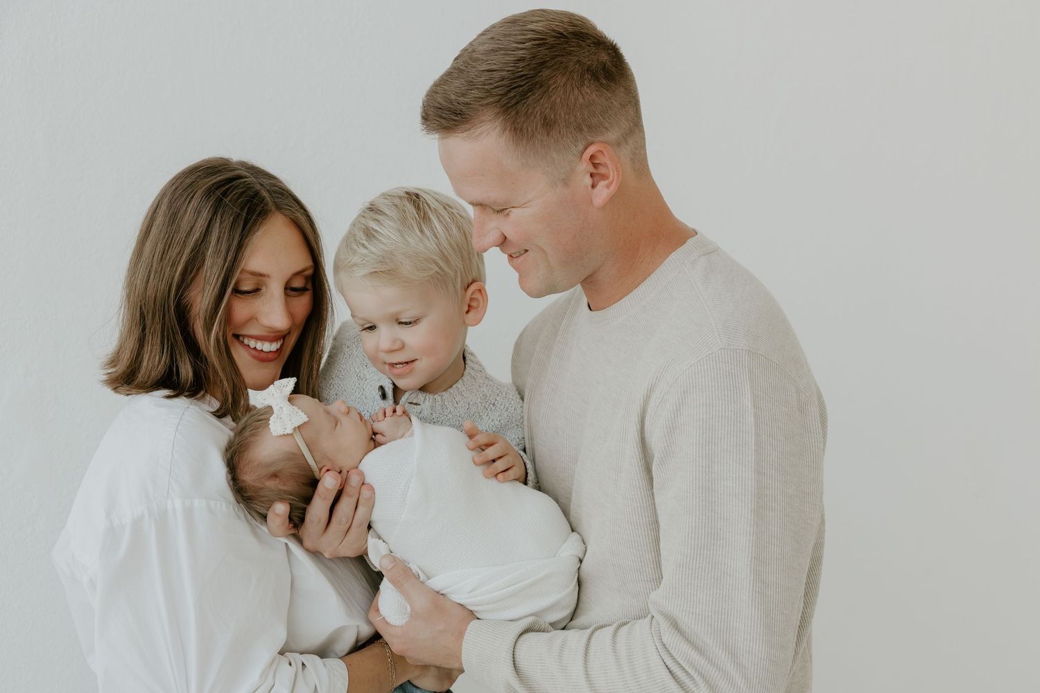 Family sharing joyful moments together while dressed in coordinating neutral colors.