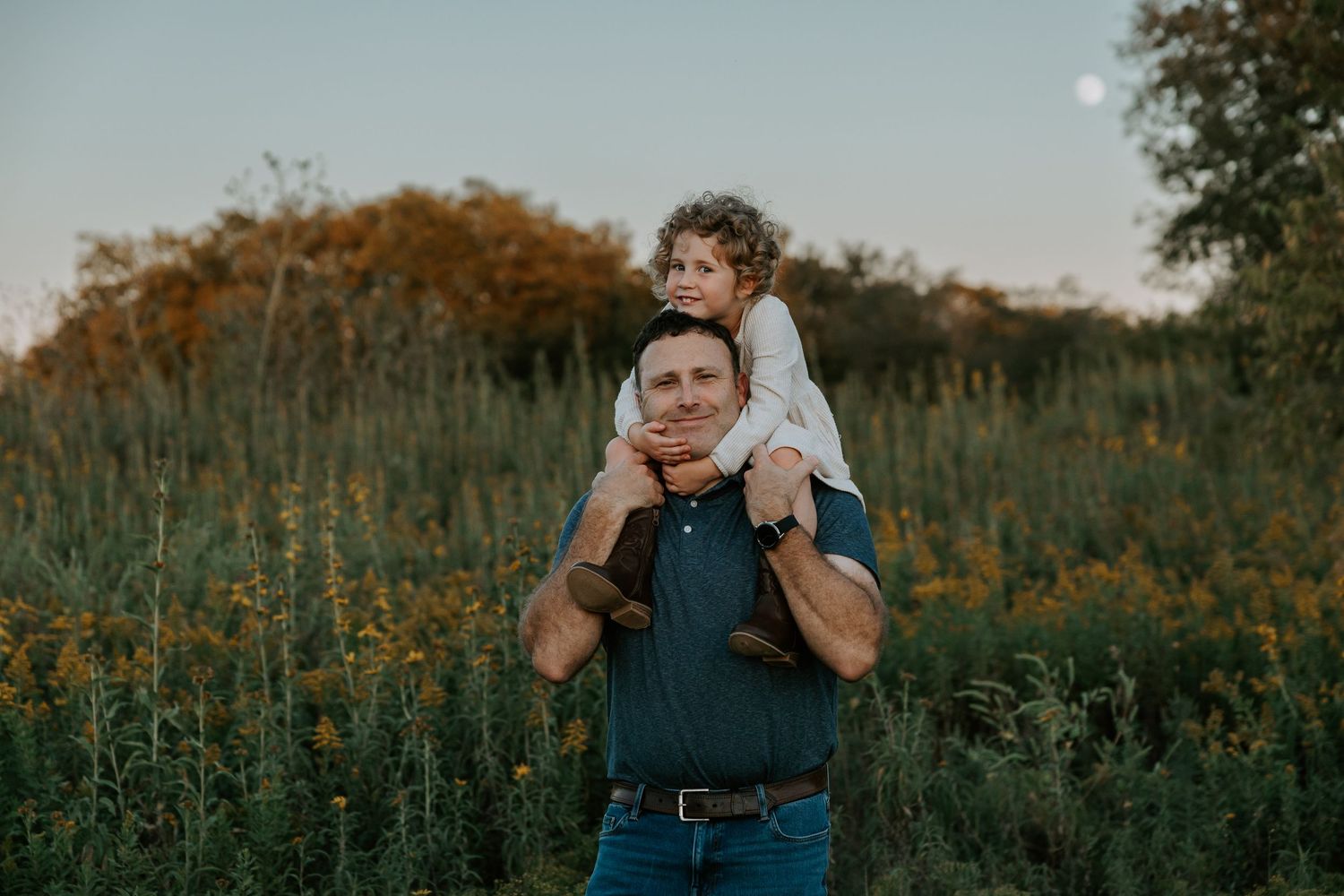 Natural outdoor family photography session in a field during golden hour.