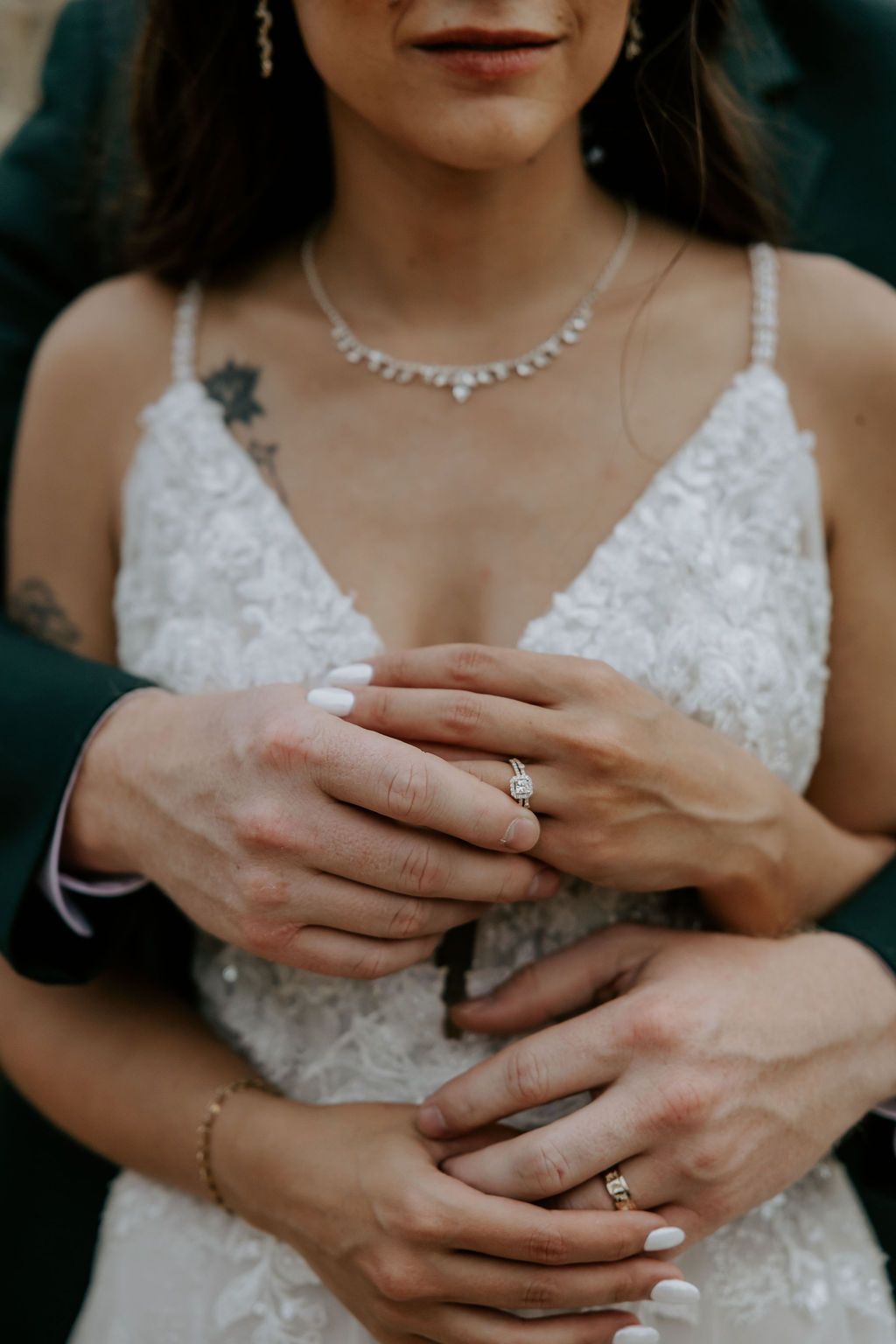 Detailed shots of hands with wedding rings and lace dress details.