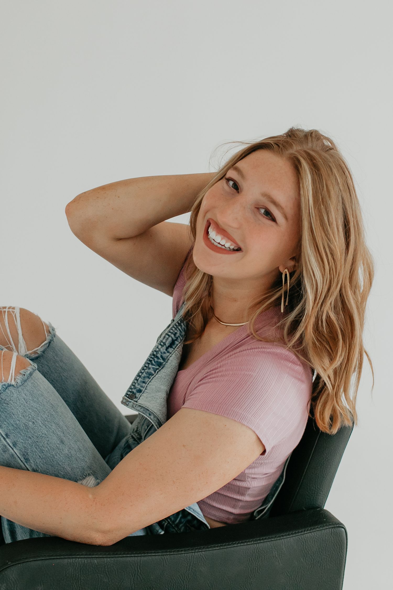 A relaxed pose on a dark chair showing joyful expressions and casual style.