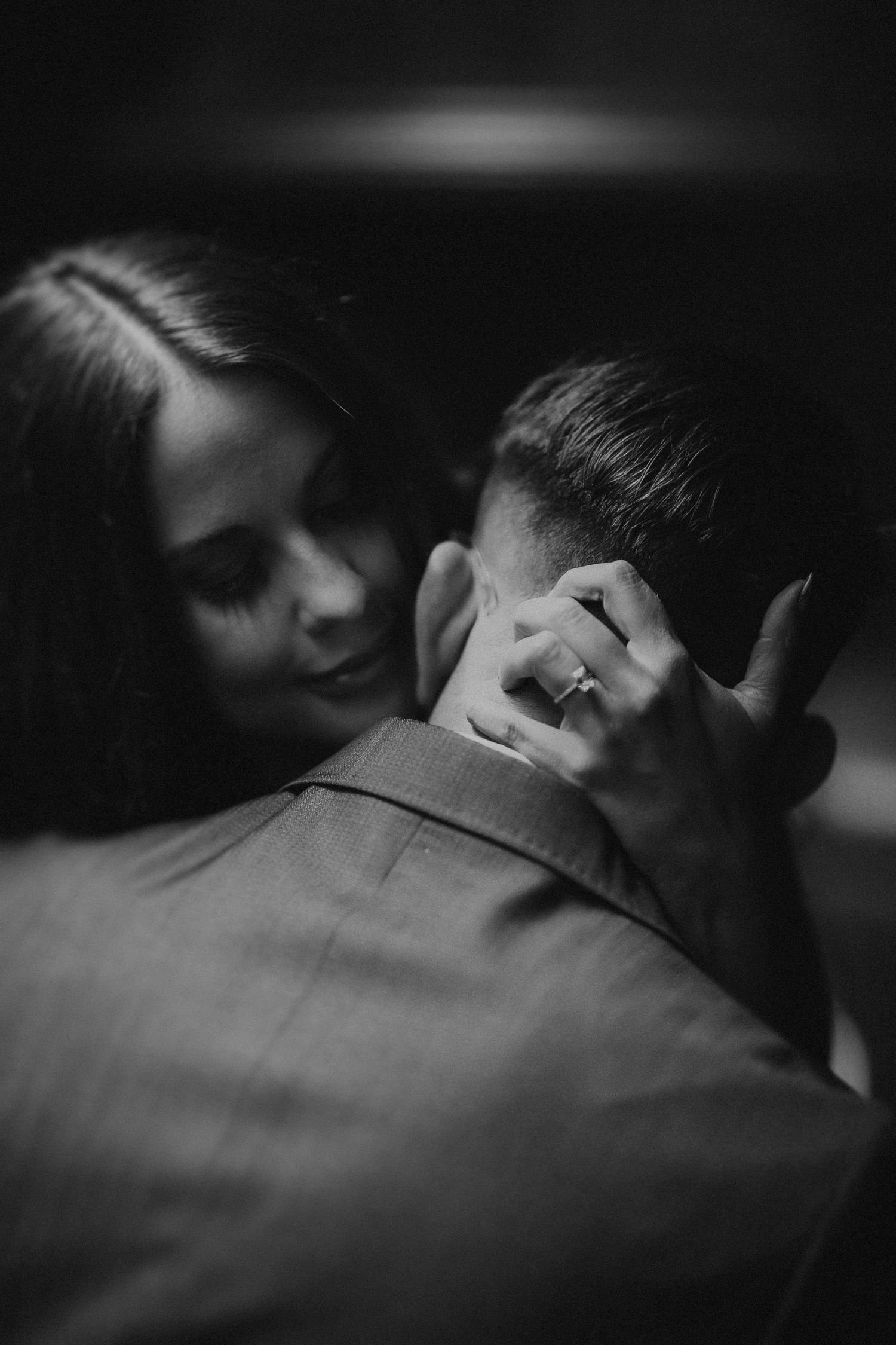 Intimate black and white portrait of couple in close embrace.