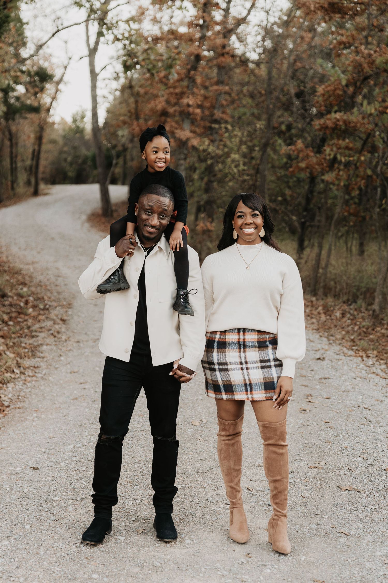 Group walking together on autumn path wearing coordinated white and neutral outfits.