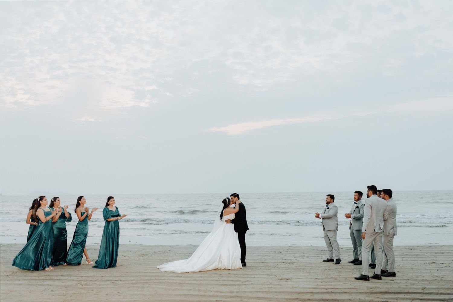 Beach wedding ceremony with bridal party in teal dresses by the ocean, beautifully captured by a wedding Photographer in Mumbai.