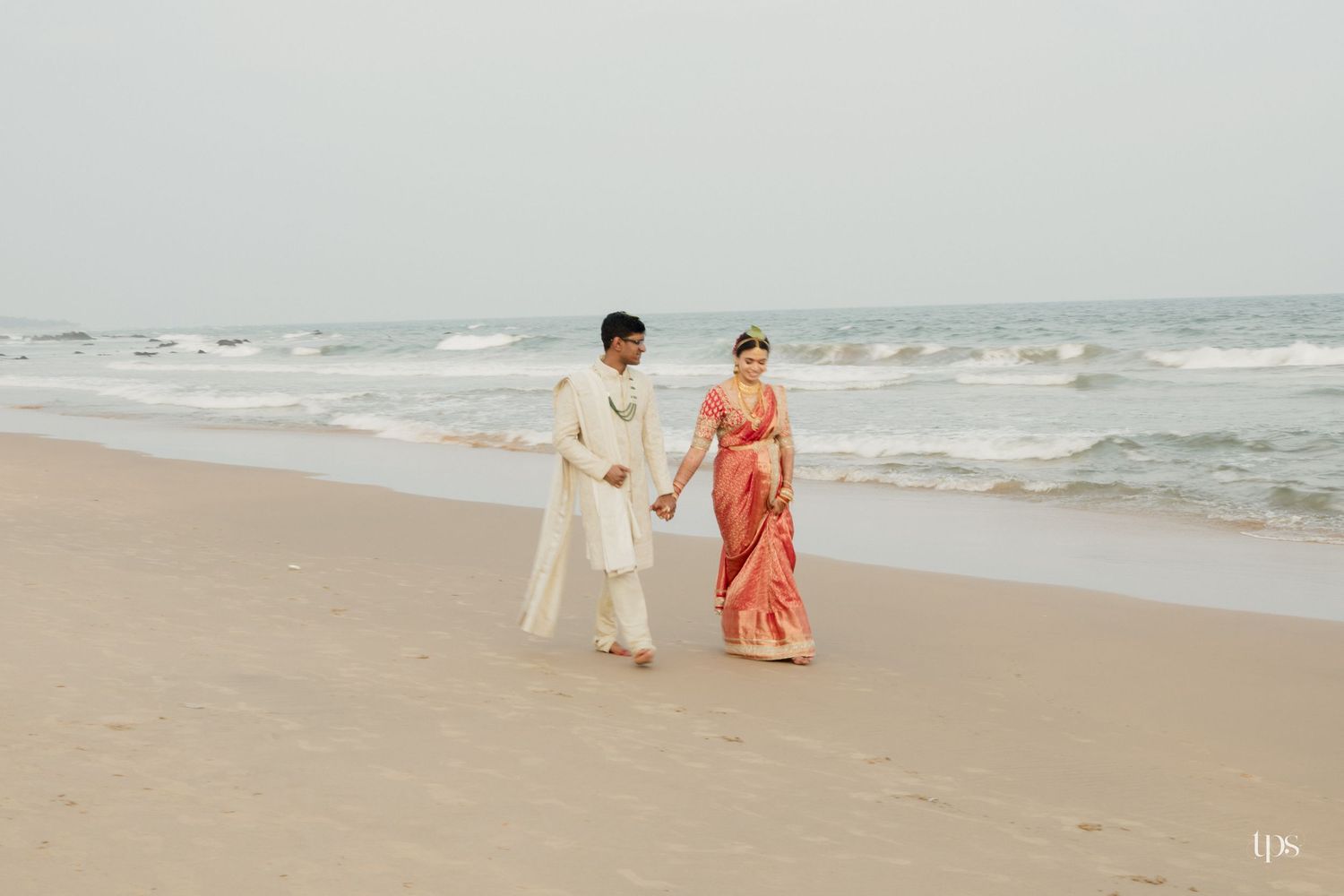Panoramic beach sunset with people walking along the shoreline, beautifully captured by a wedding Photographer in Mumbai.