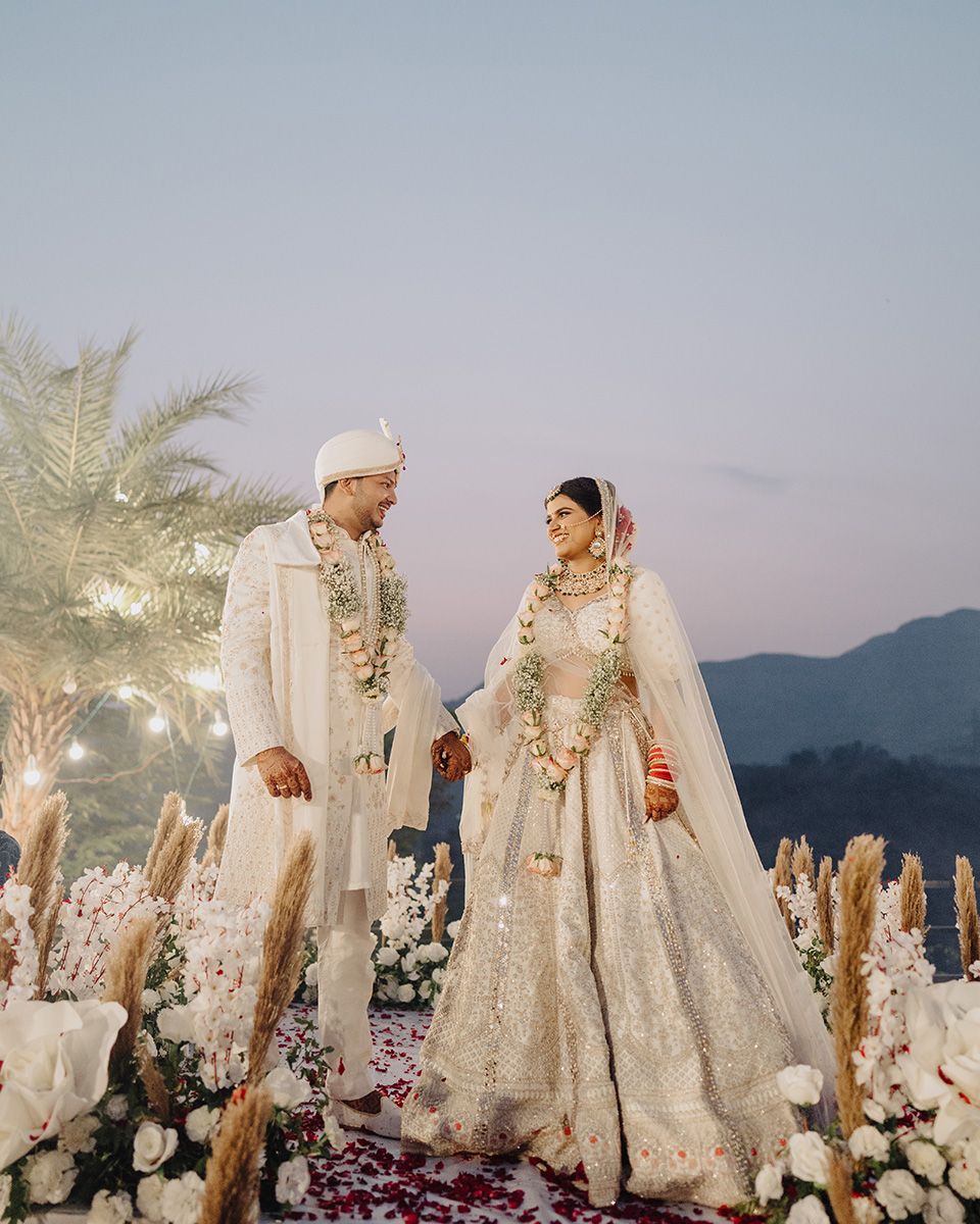 Elegant white wedding outfits against a mountain sunset backdrop, captured by a wedding Photographer in Mumbai, Wedding photographer near me