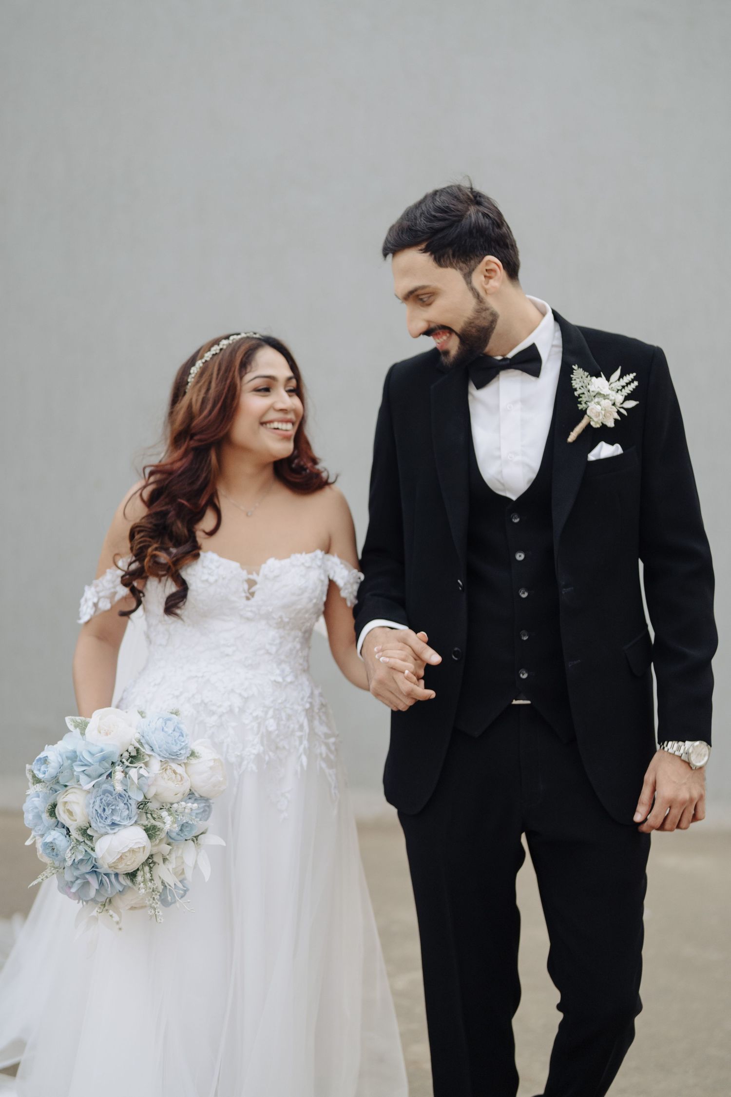 Intimate wedding portrait in formal outfits against a grey backdrop by a wedding Photographer in Mumbai, Wedding photographer near me