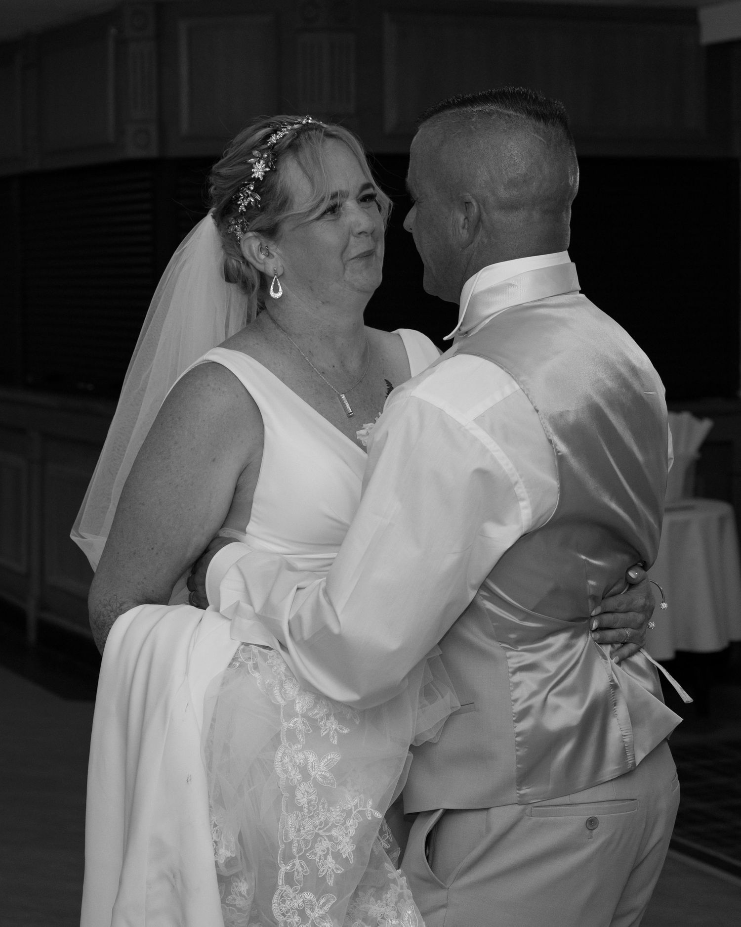 Black and white photo of couple dancing at their wedding reception.