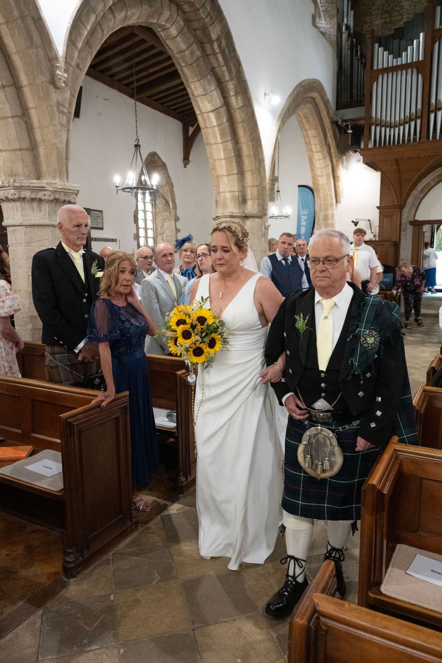 Wedding ceremony photos inside a historic stone church with arched ceilings and wooden pews.