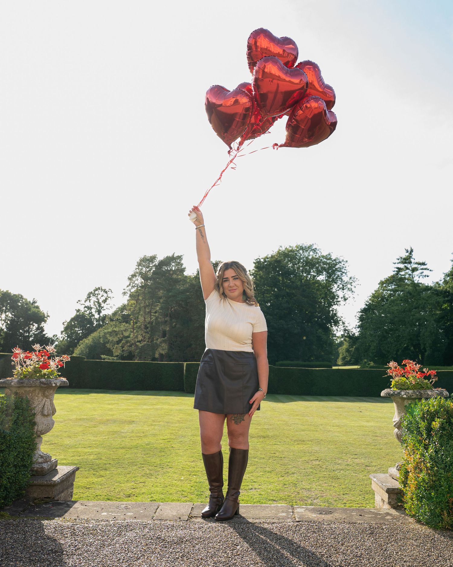 A series of outdoor photos showing someone holding red heart-shaped balloons against a garden backdrop.