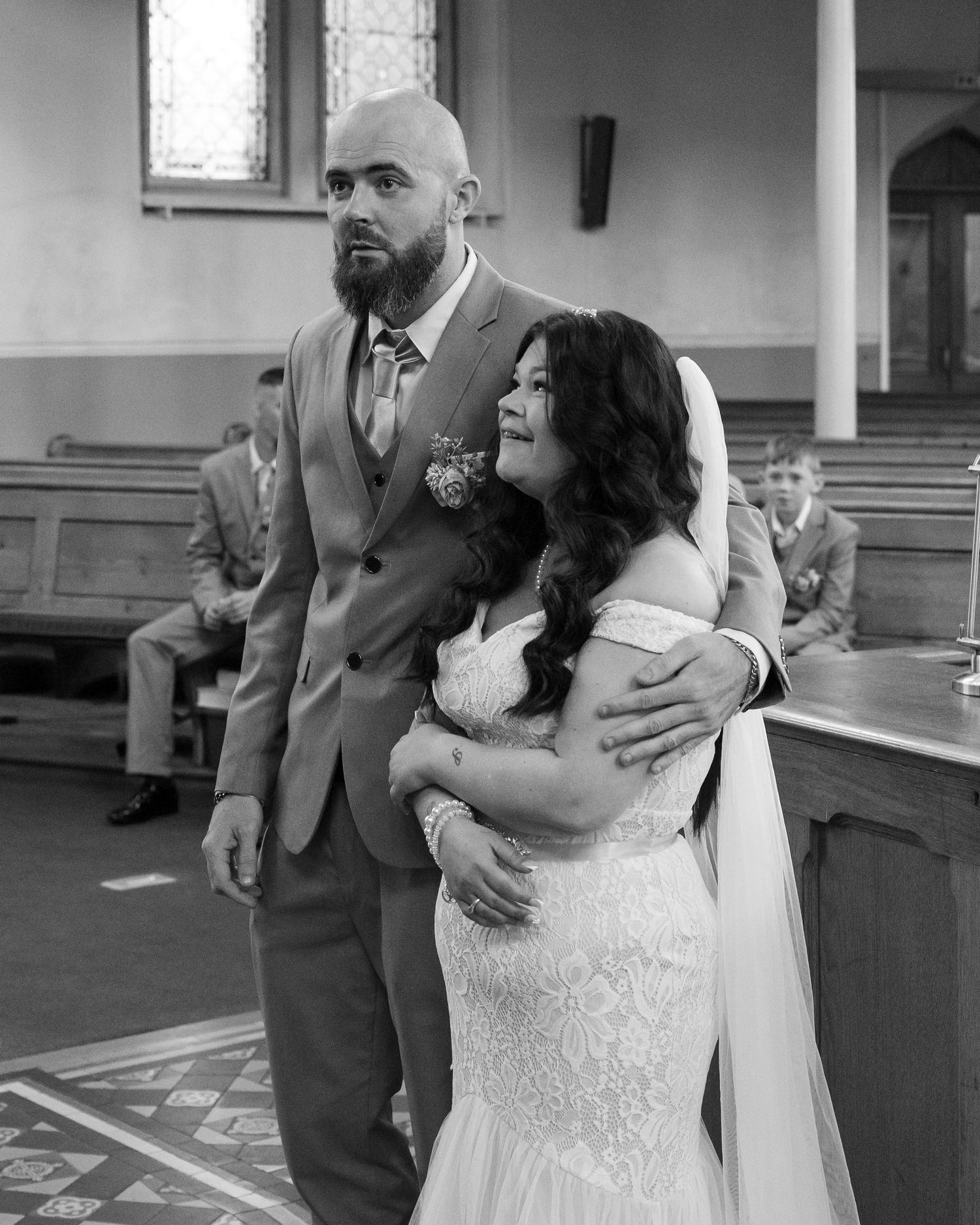 A couple shares a tender moment during their wedding ceremony in a church setting.