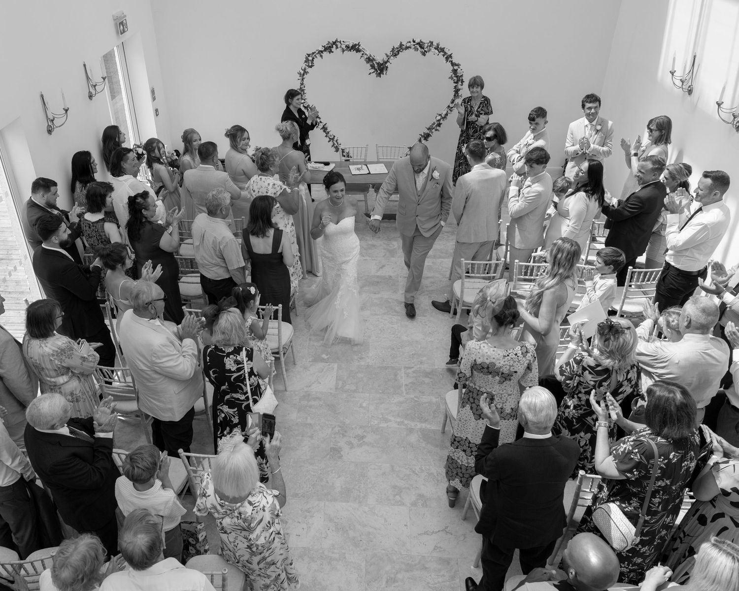 Large crowd of wedding guests gathered indoors for a reception celebration.