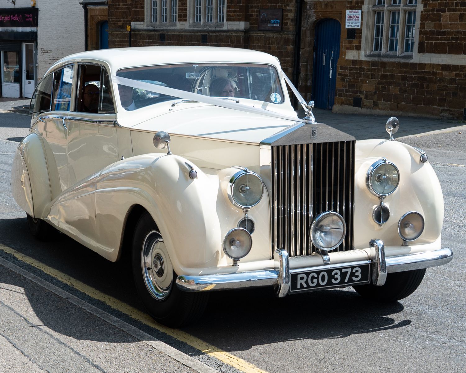 Classic white Rolls Royce wedding car parked on street in multiple views.