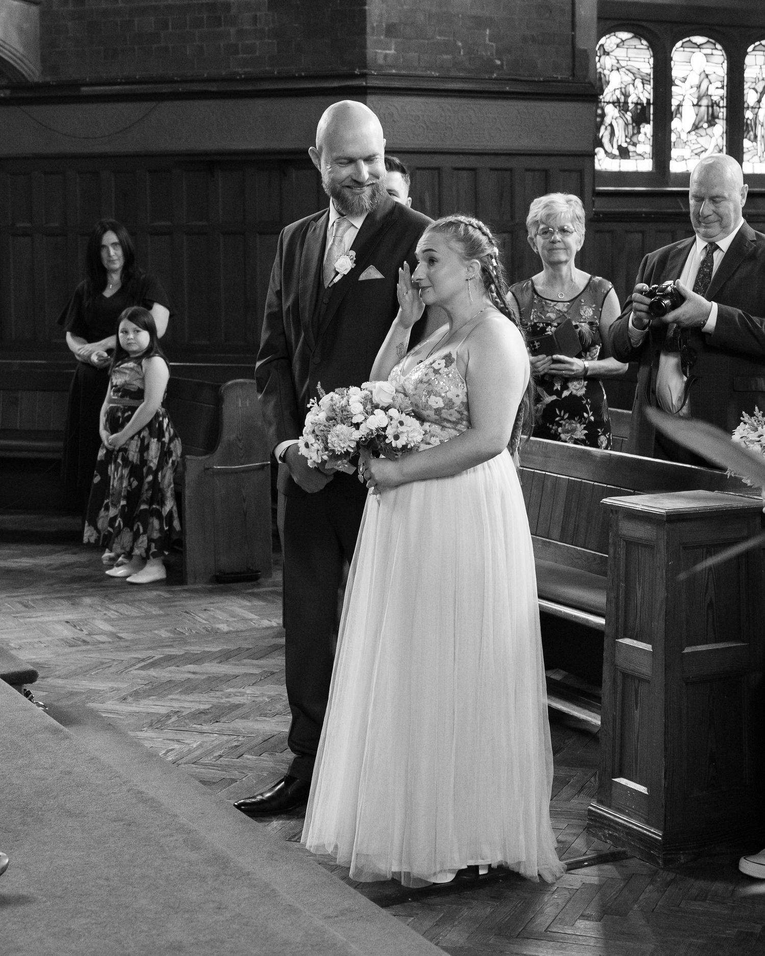 Black and white photos of a wedding ceremony taking place in a traditional church setting.
