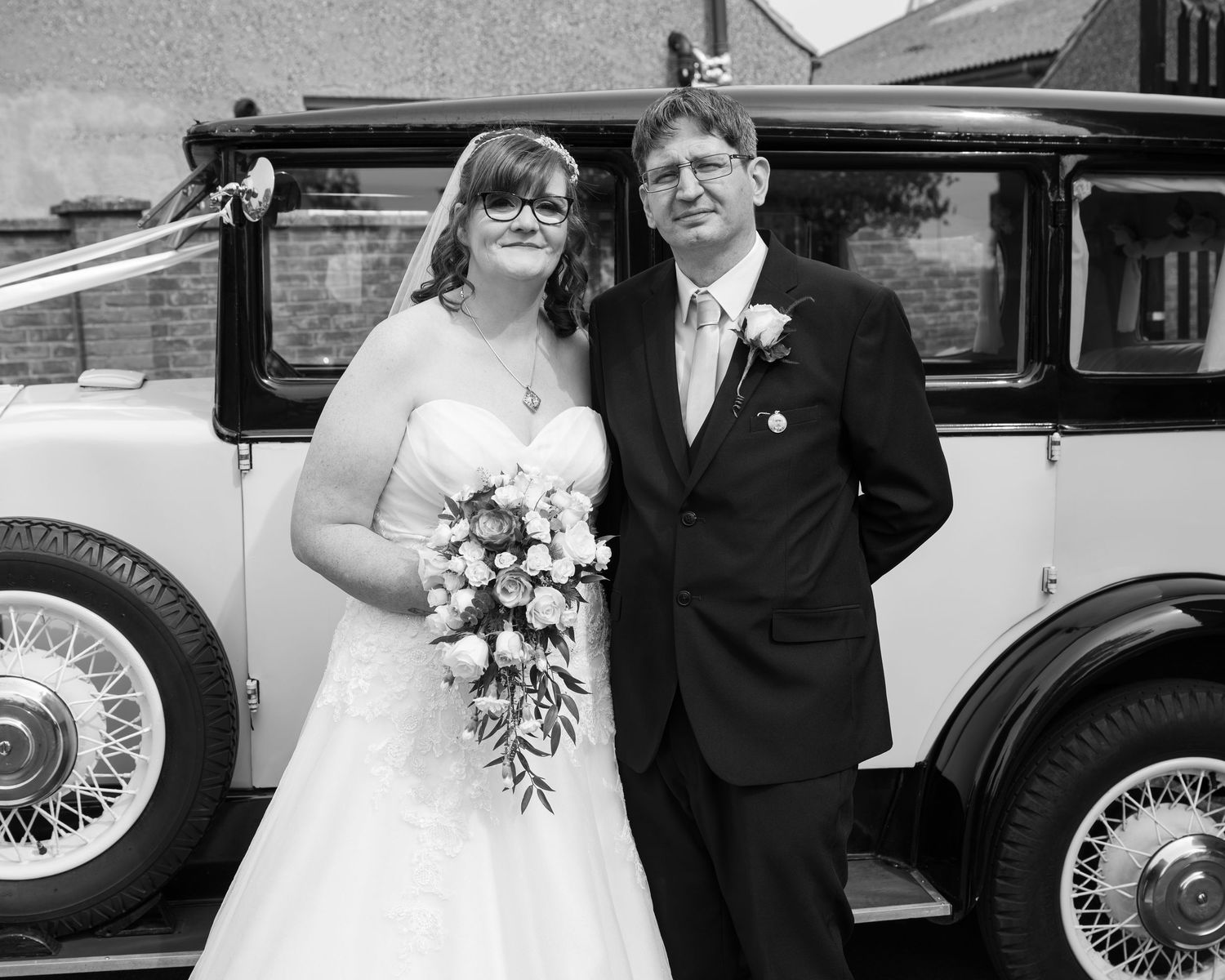 Classic vintage wedding car featured in black and white photography.