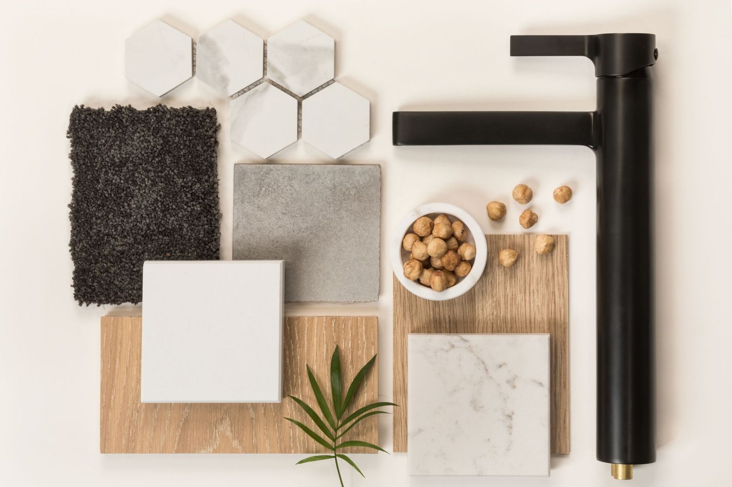 Flat lay of interior design mood board with marble tiles, wood samples, black faucet, gray carpet, and decorative elements.