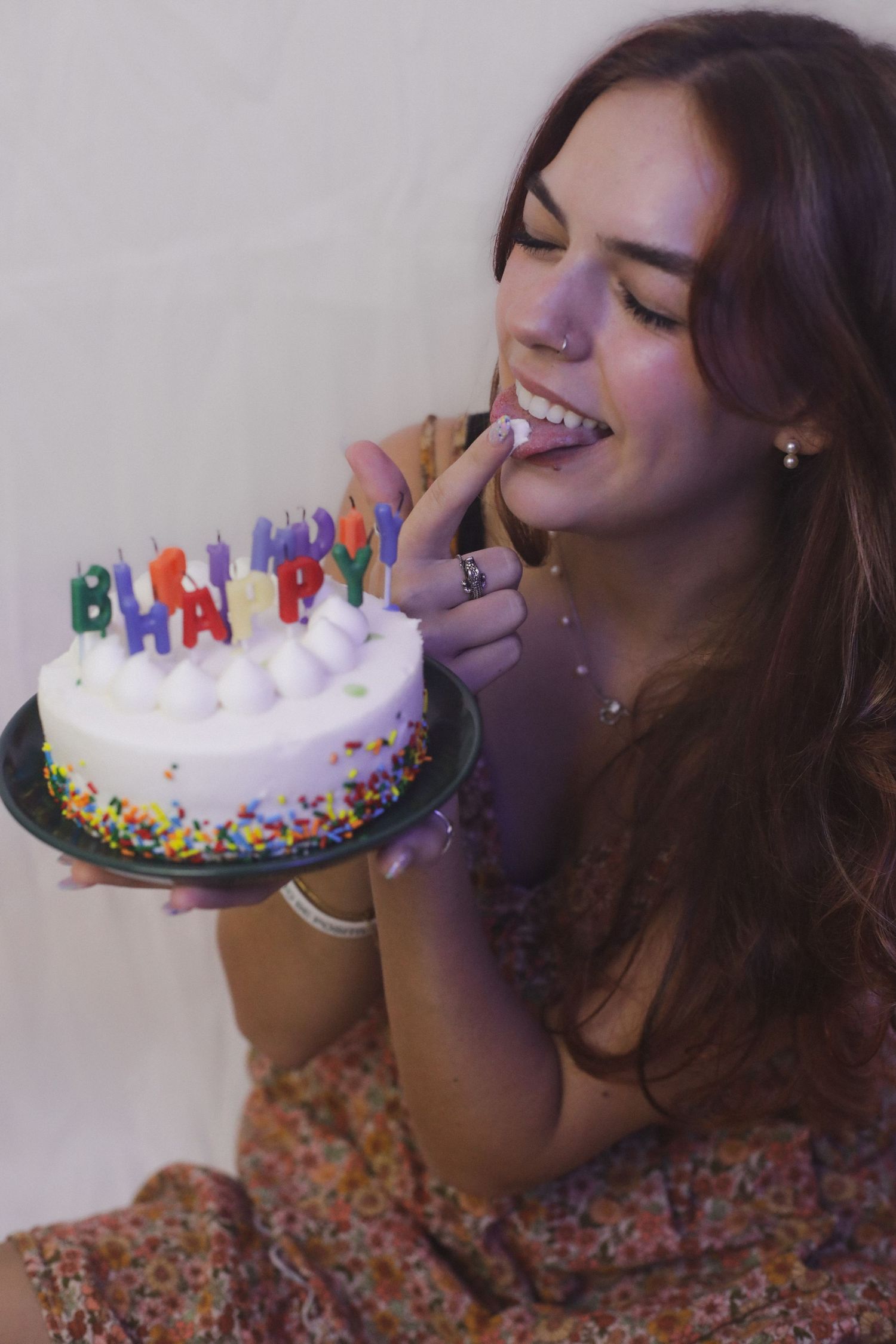 Woman playfully eating cake for a birthday photography session. Goodreau.co