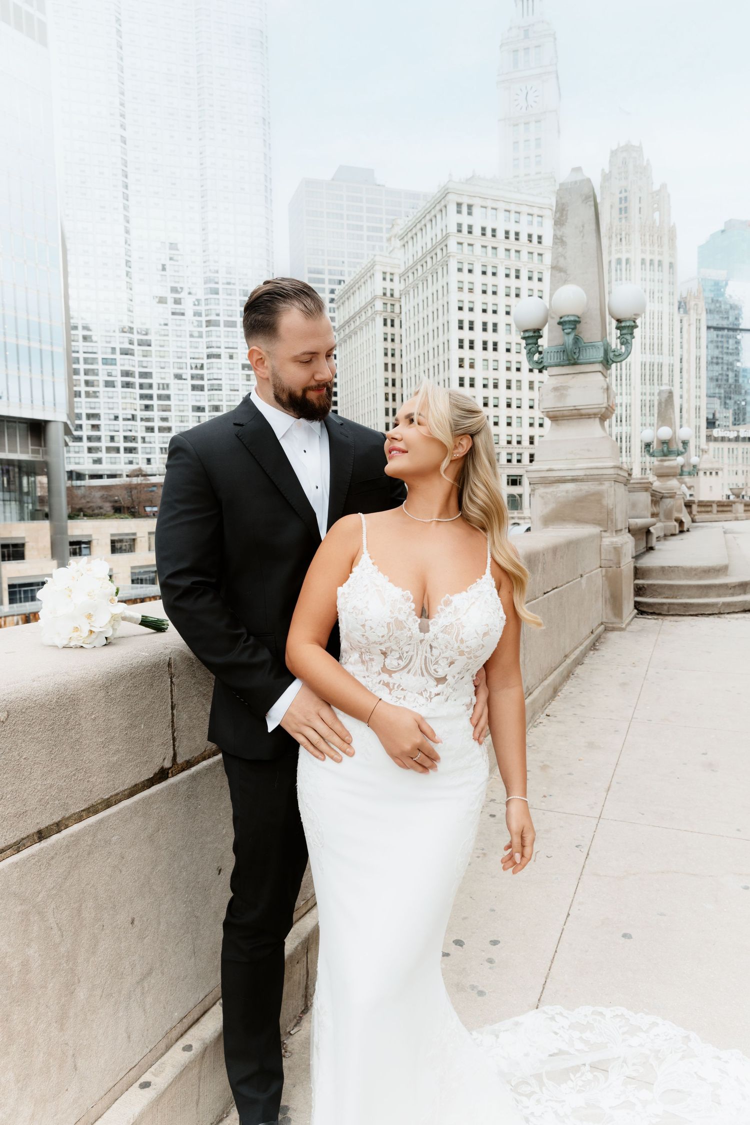 Bride and groom share a romantic moment on a Chicago rooftop terrace with city skyline views.
