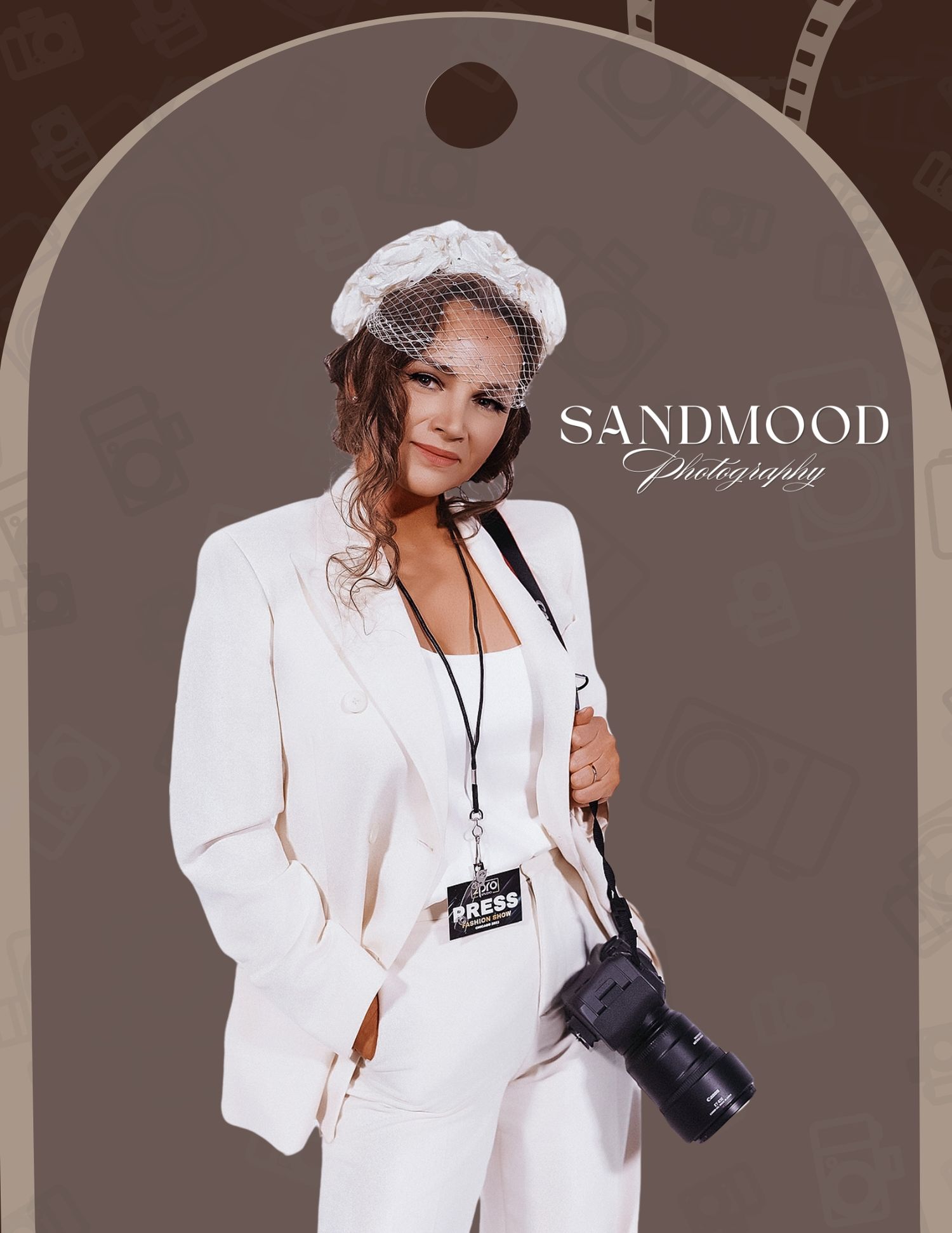 Woman in white suit and beret hat holding camera with Sandmood Photography press badge.