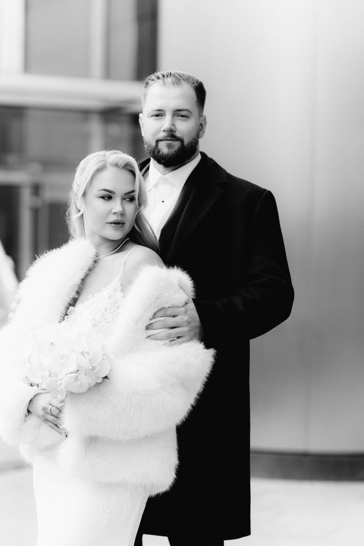 Classic black and white portrait of bride in fur stole and bearded groom.