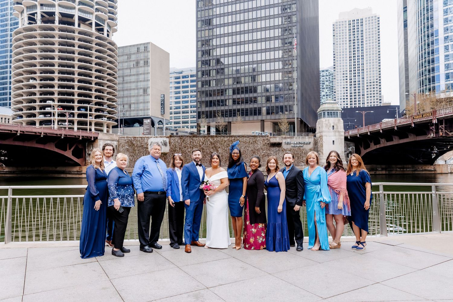Wedding party group portrait with bride and groom on Chicago Riverwalk with skyline and bridge.