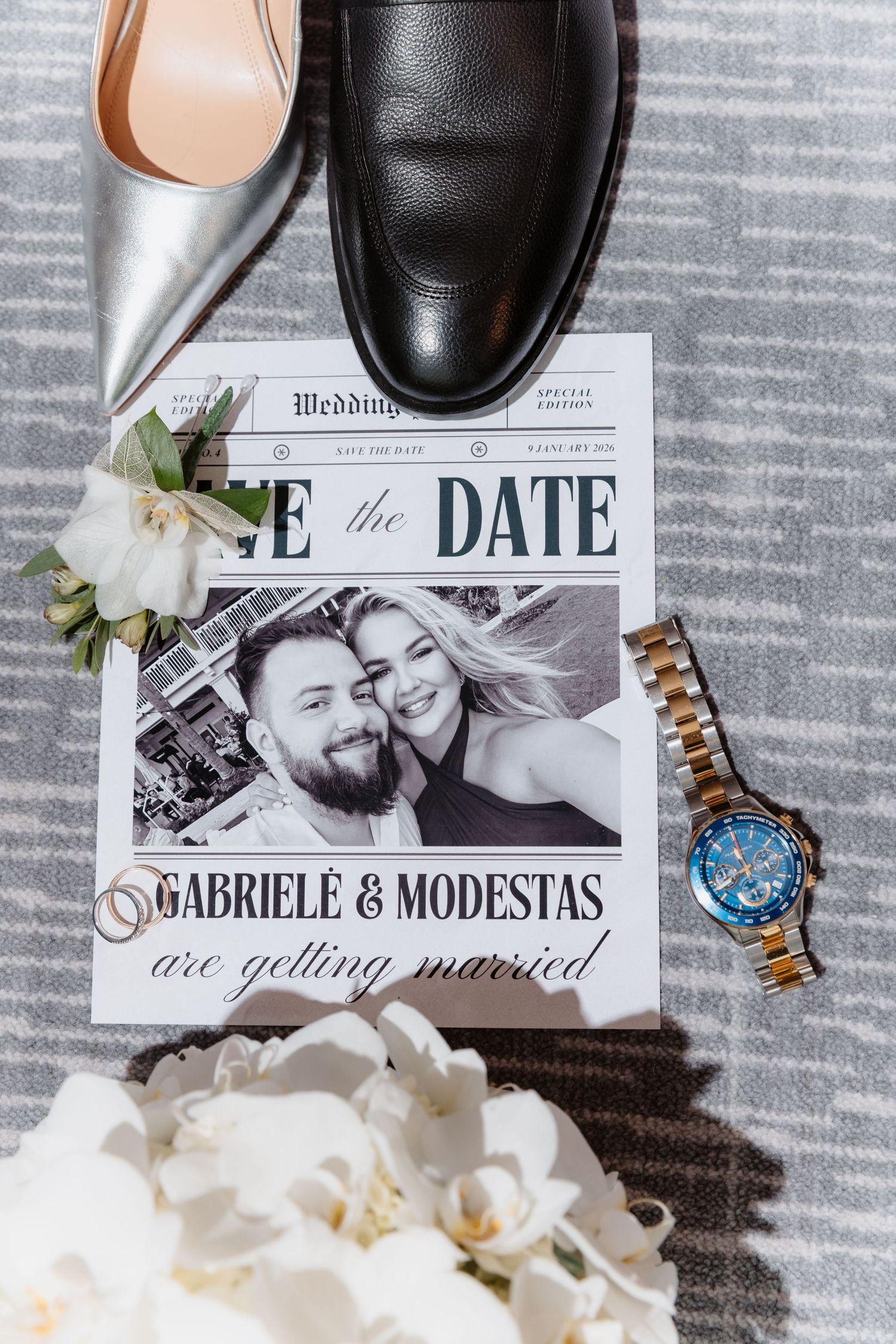 Save the date wedding newspaper featuring Gabriele and Modestas with rings, orchids, silver heels, black shoes, and a watch.