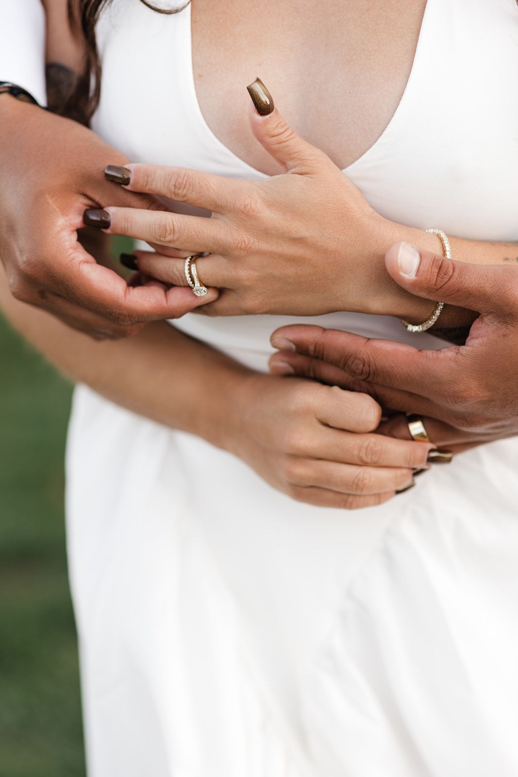 Close-up of bride and groom exchanging wedding rings, bride wearing white dress with diamond band.