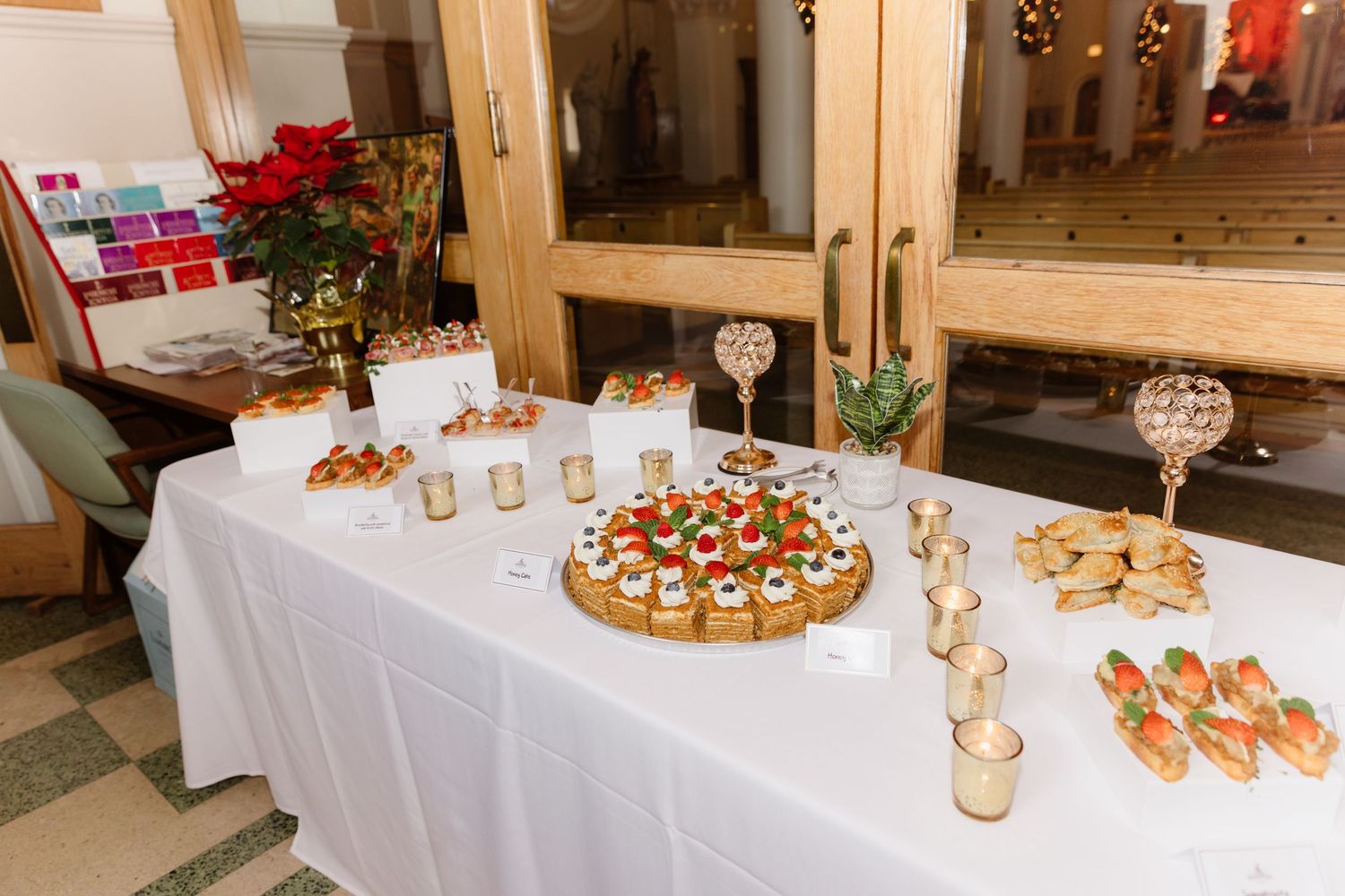 Elegant white reception table with assorted appetizers, canapes, and crystal candle holders.