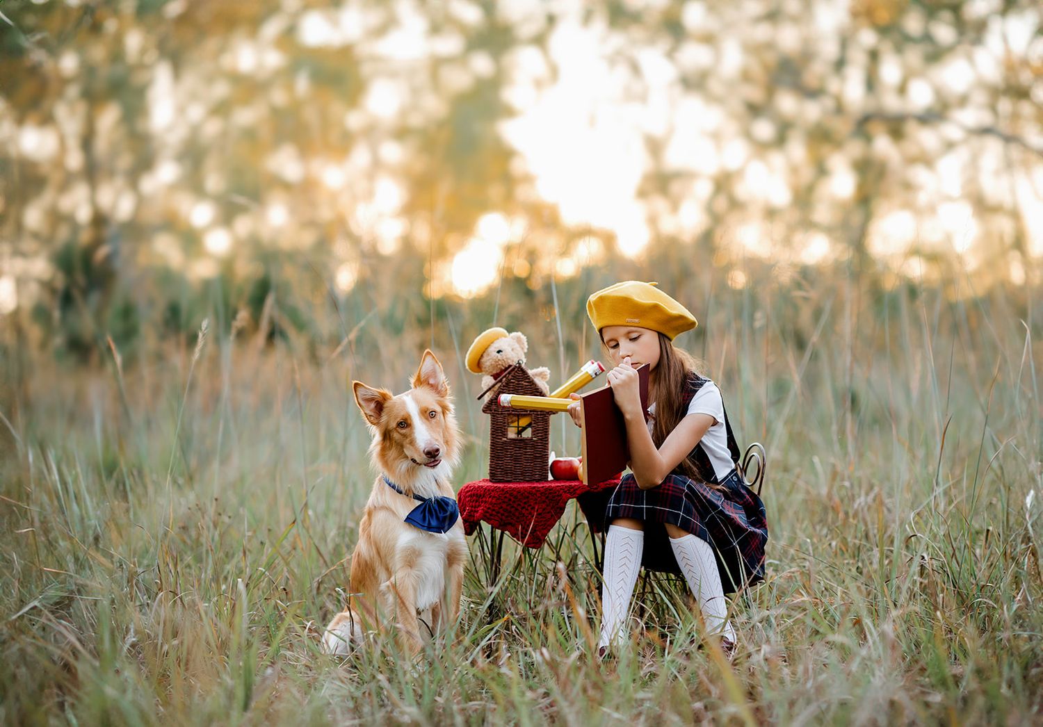 A young girl in a yellow beret shares a picnic with her golden dog in a sunlit meadow.