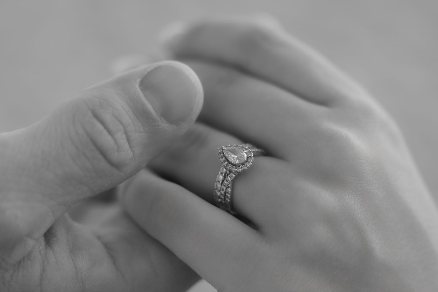 Black and white close-up of hands holding, showcasing a beautiful  diamond ring during an engagement photoshoot in Charleston, SC.