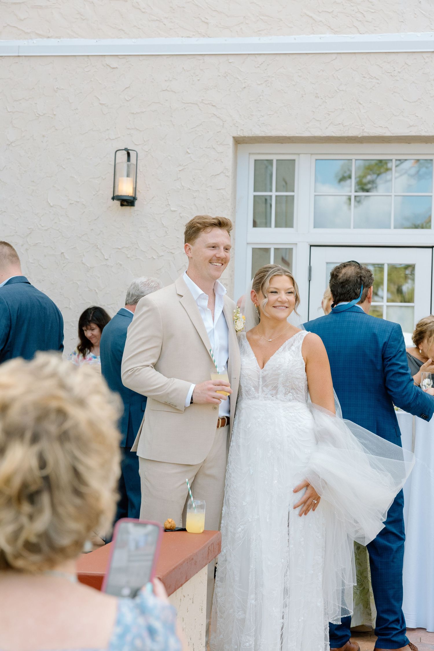 Smiling bride and groom posing together during outdoor cocktail hour at elegant Florida wedding venue.
