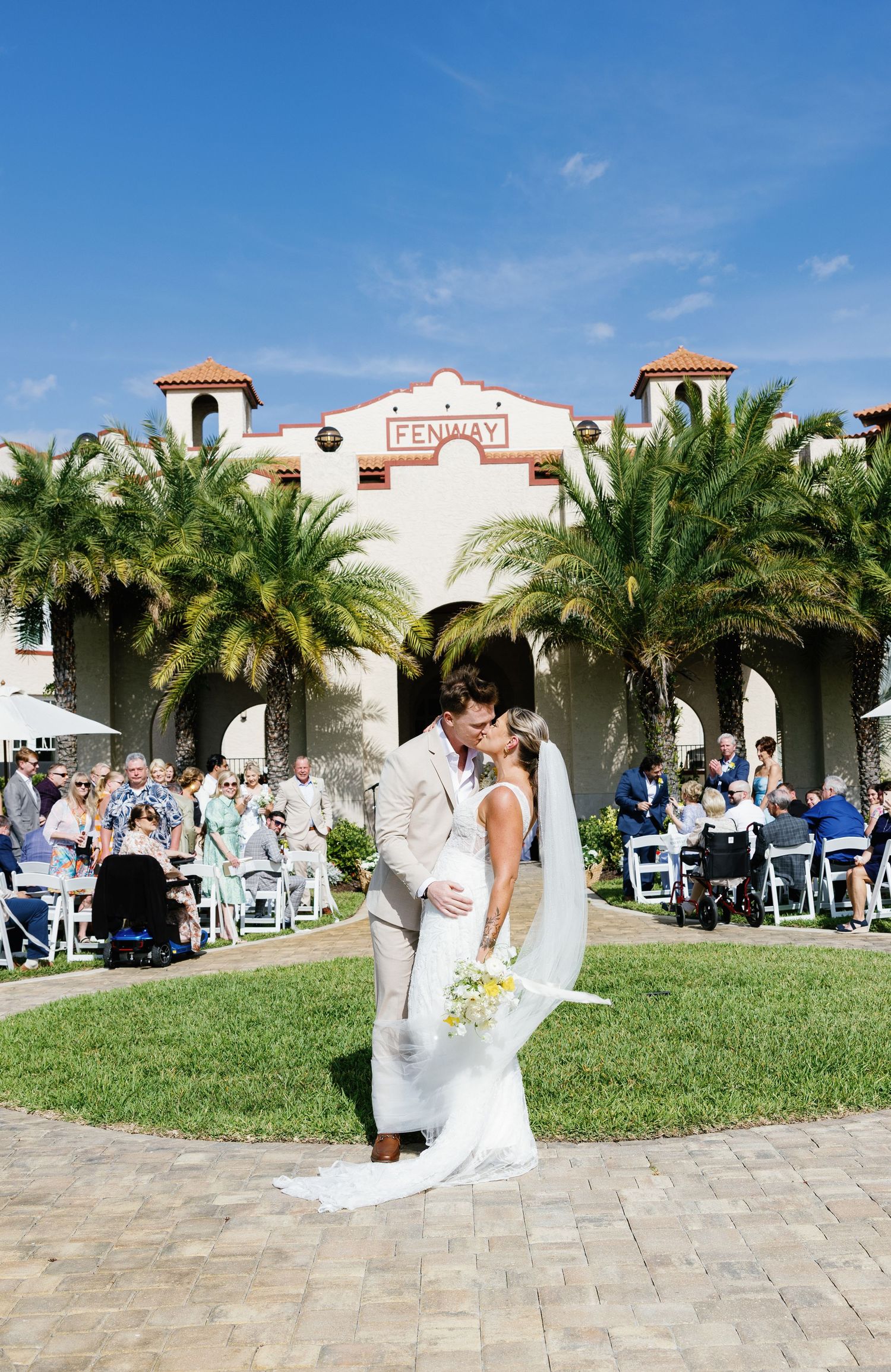 Newlyweds sharing a first kiss after outdoor ceremony at the historic Fenway Hotel in Florida.