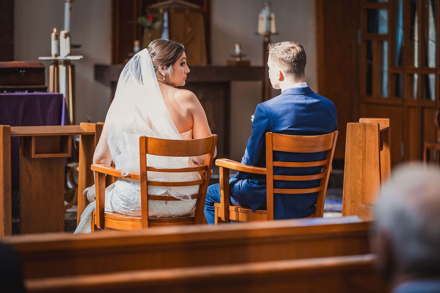 Bride and groom sit together at the altar during a church wedding ceremony.
