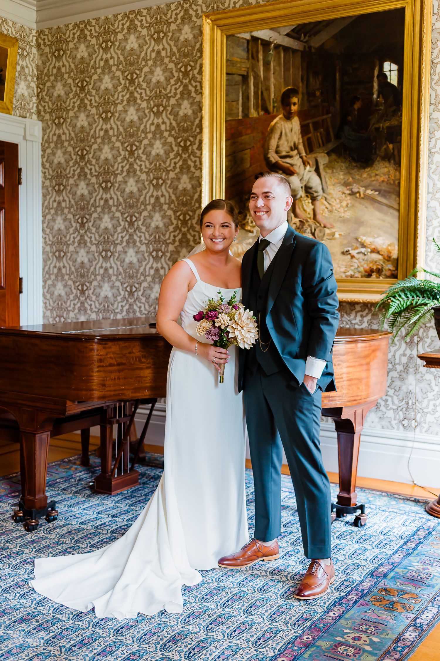 Bride and groom smiling in elegant room with grand piano and artwork.