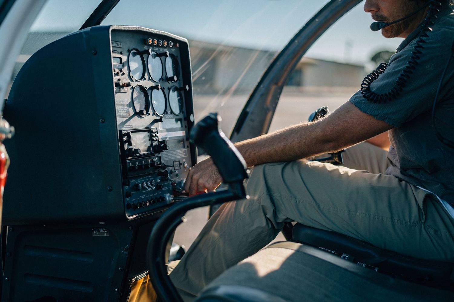 Close-up view of helicopter cockpit controls and instrument panel during flight operation.