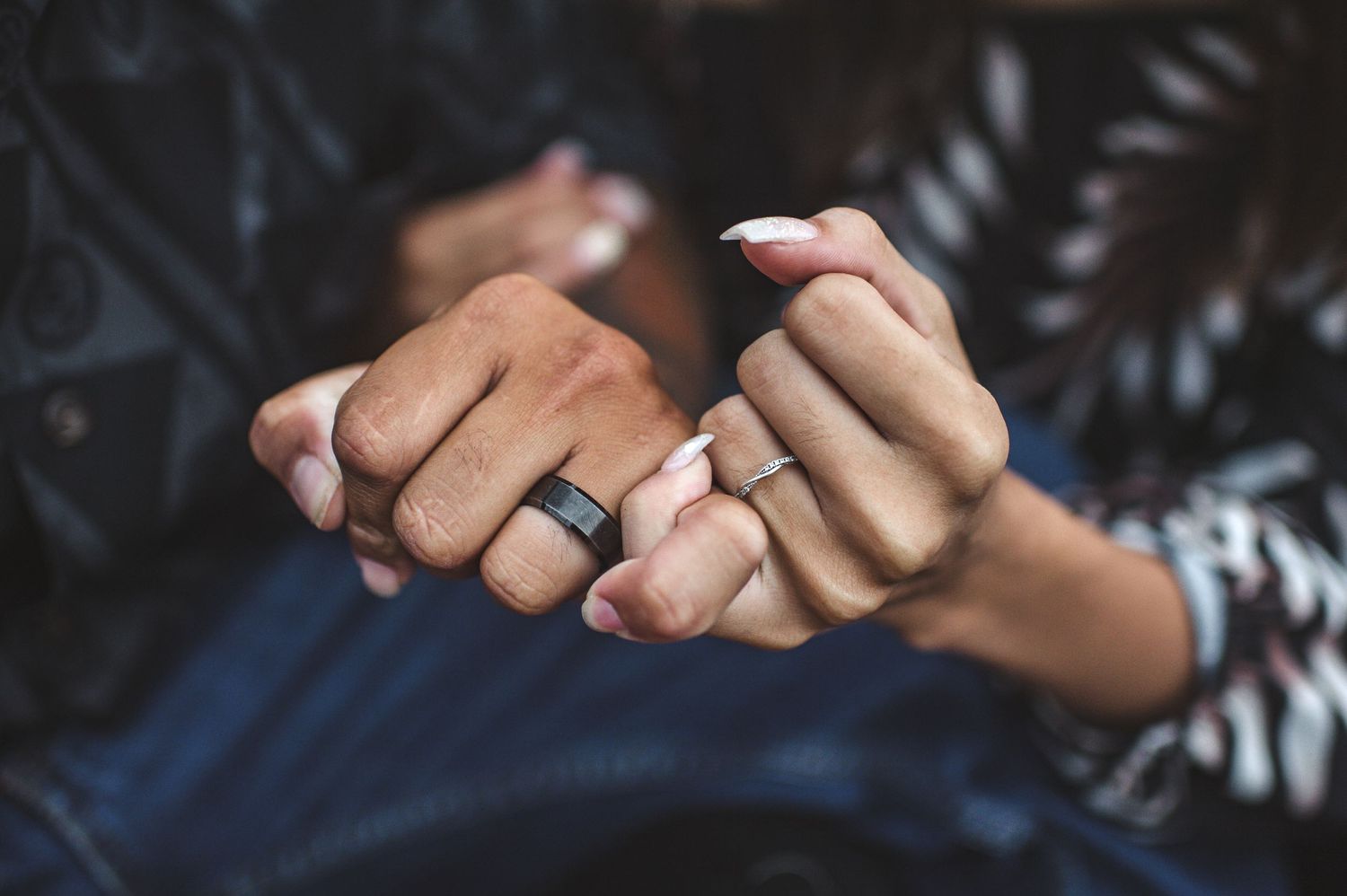 Close-up of intertwined hands showing intimacy and connection.