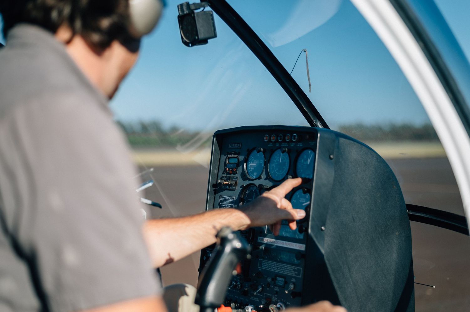 Interior view of helicopter cockpit showing flight controls and dashboard instruments.