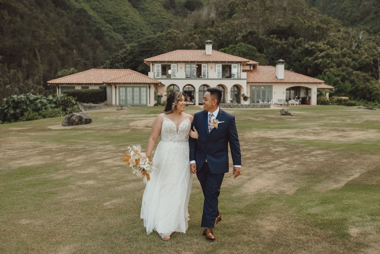 Scenic wedding venue with Spanish-style architecture nestled in lush green hillside.