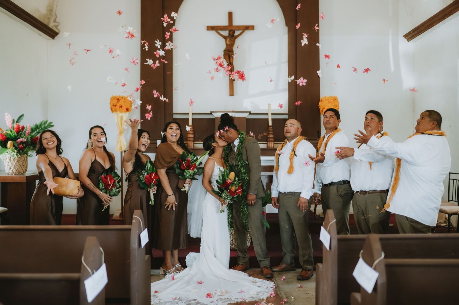 Wedding celebration in church with wooden pews and cross visible in background.