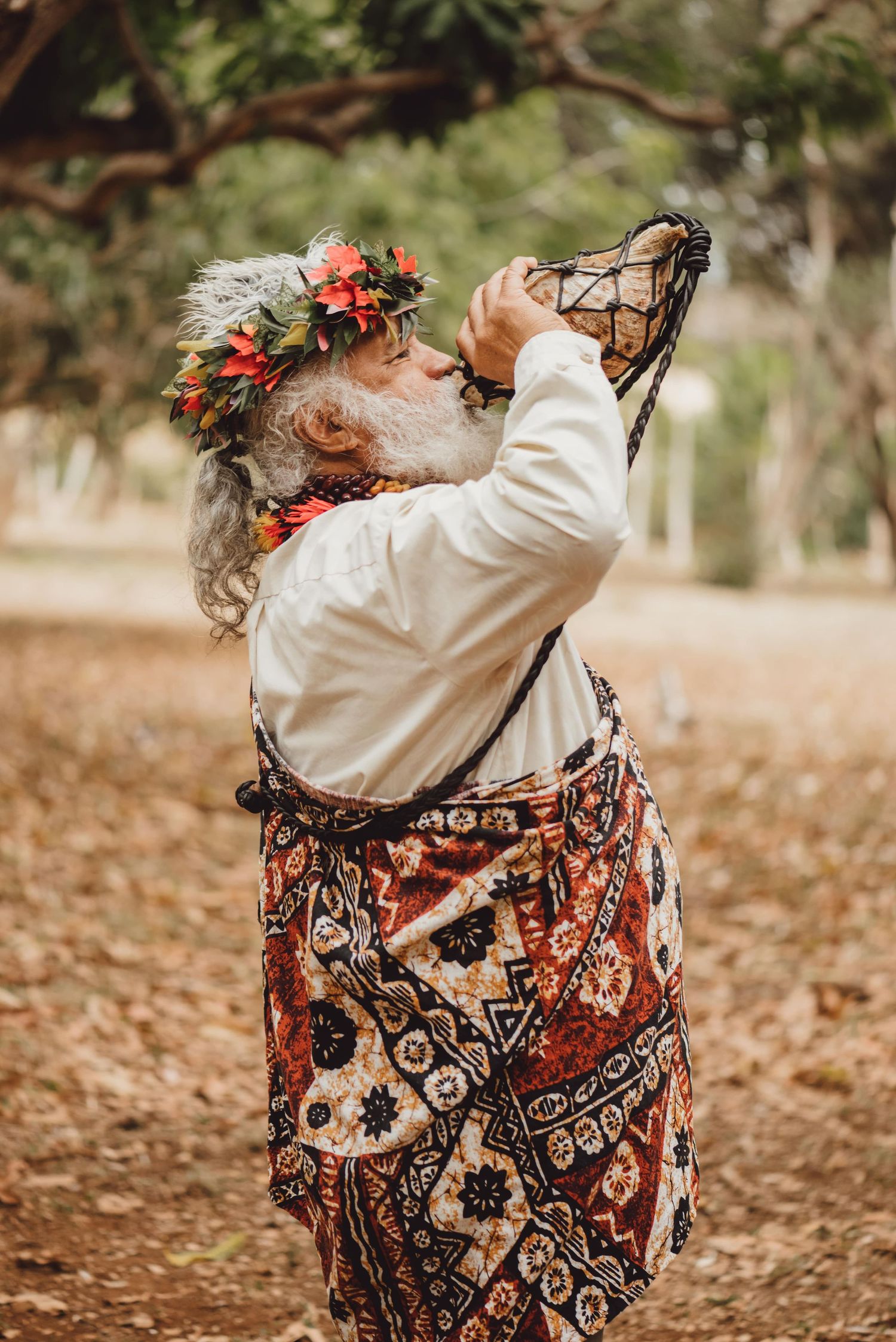 Wedding guest in floral dress swings joyfully on a tree swing during outdoor celebration.