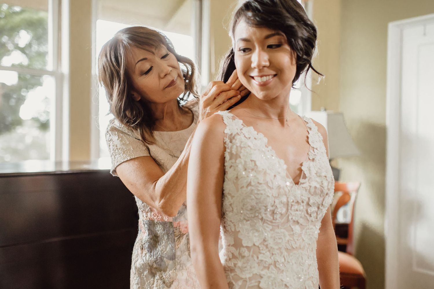 Getting ready moments in a sunlit room with elegant wedding attire.