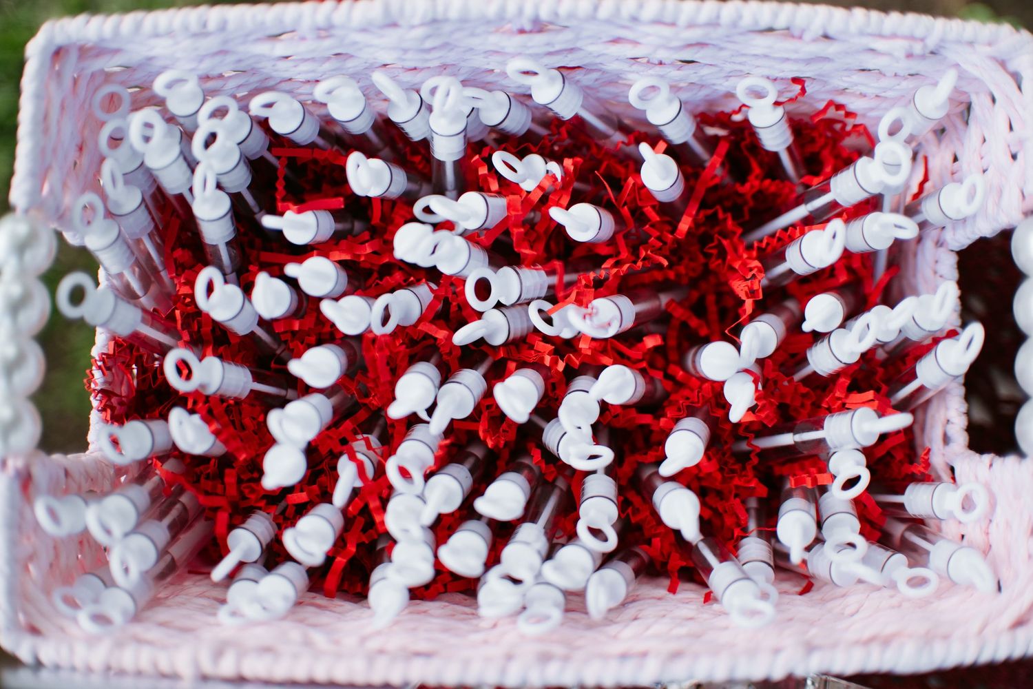 A basket filled with red and white decorative craft picks with white heart-shaped tips for floral arrangements.