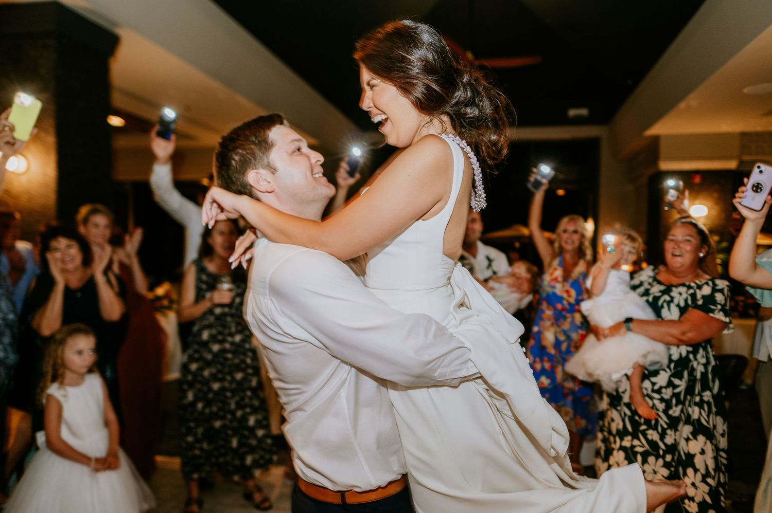 Wedding guests dancing and celebrating with enthusiasm during reception party.