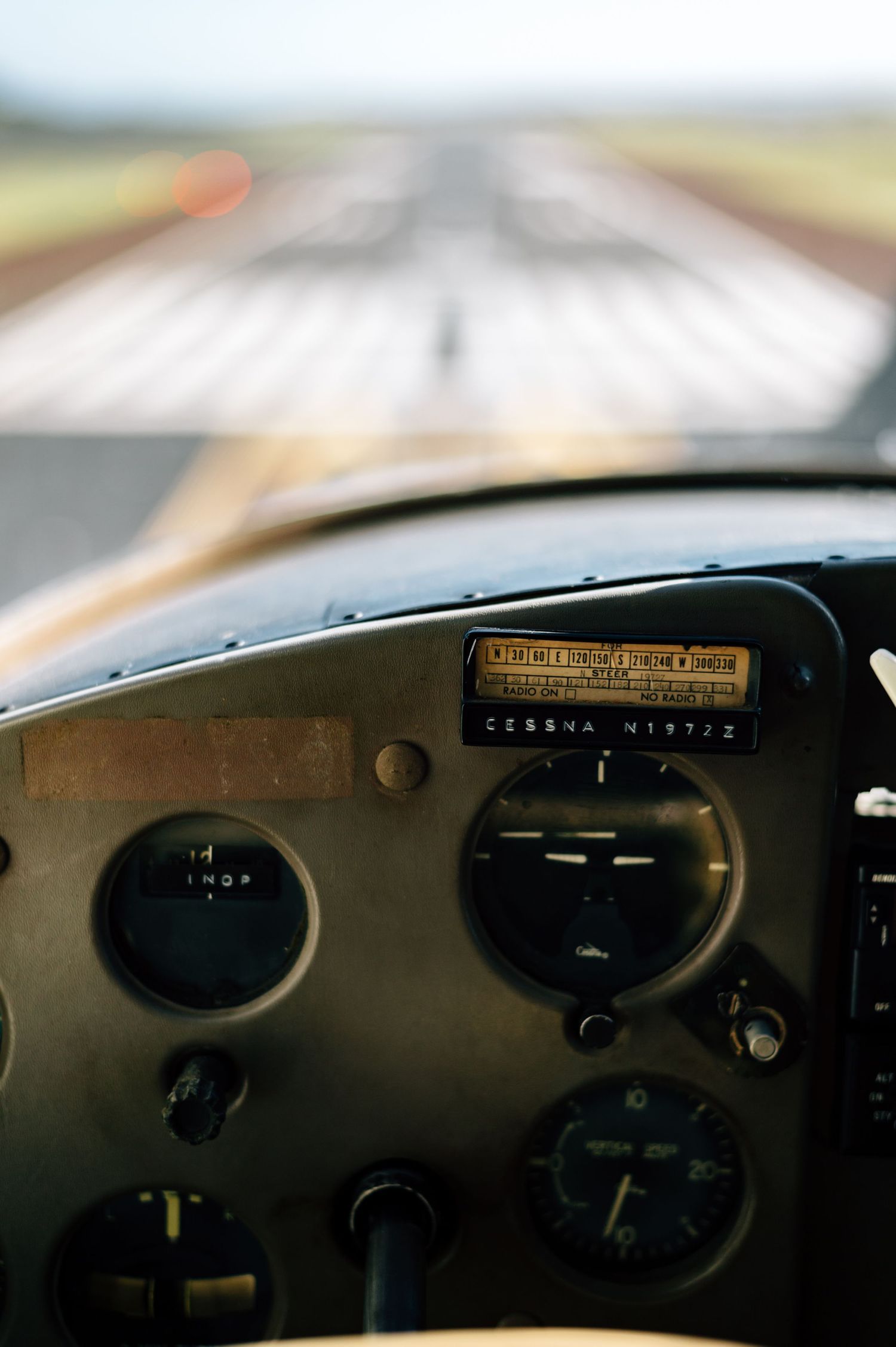View through aircraft windshield showing flight instruments and runway ahead.