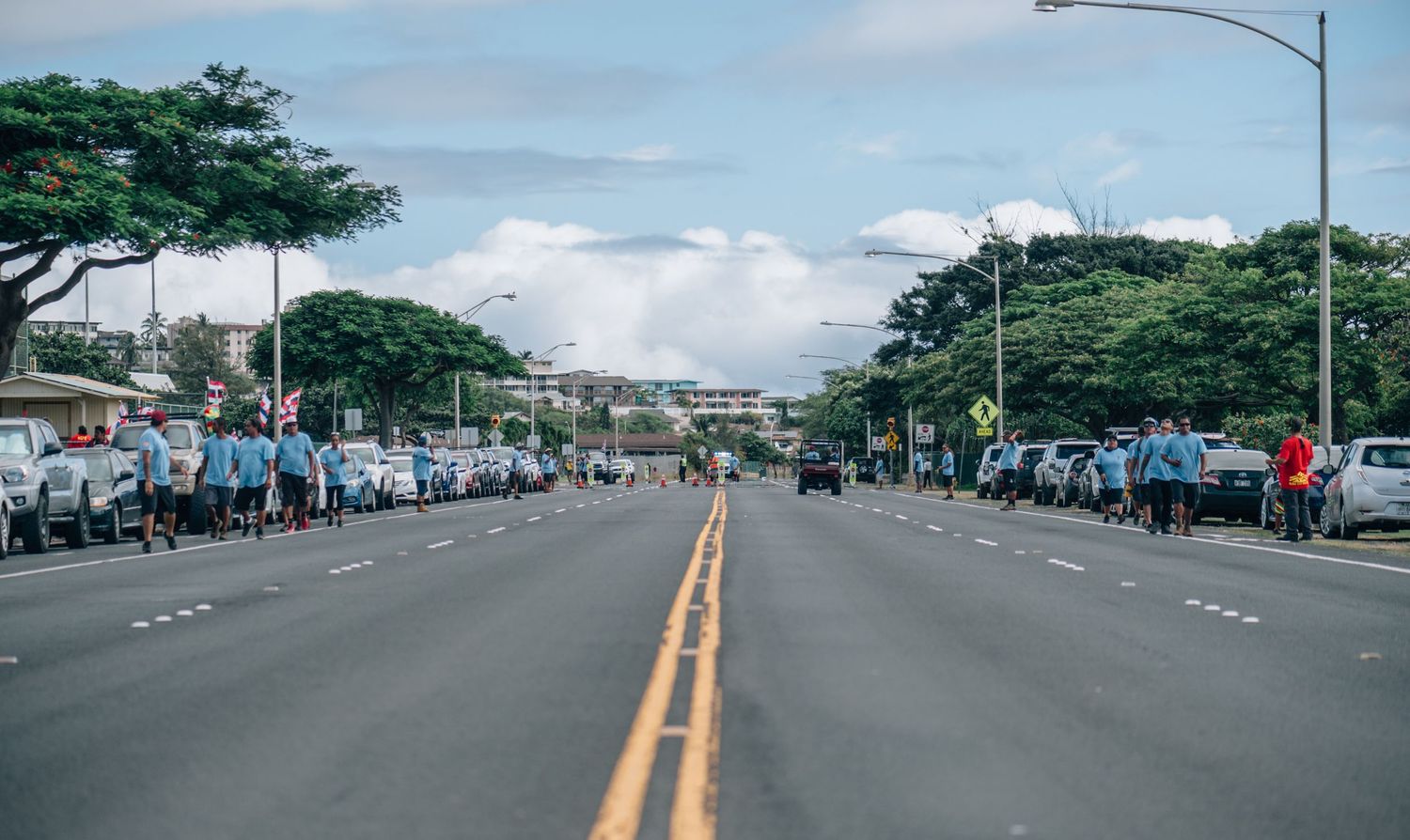 Empty street with road markings and palm trees visible in Hawaii.