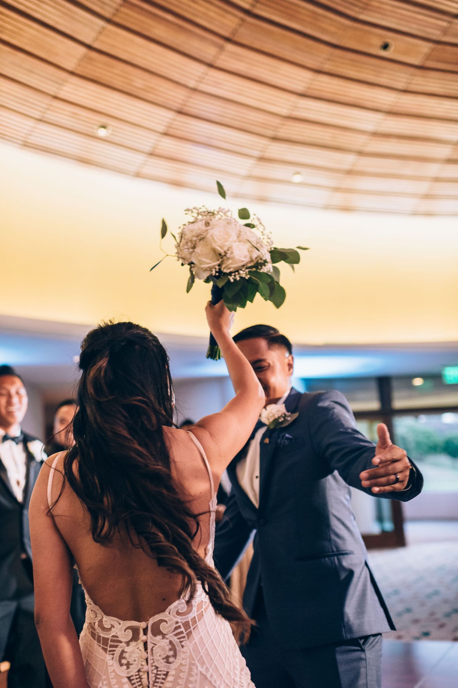 Wedding celebration features coordinated dance moves in an elegant indoor venue with curved ceiling.