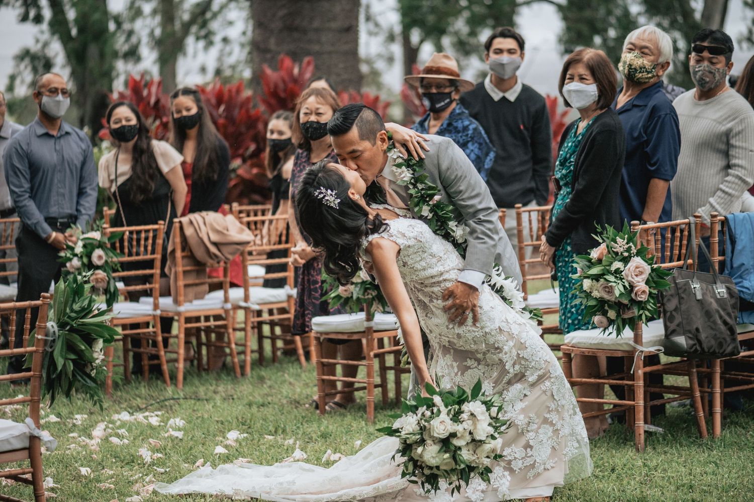 Wedding celebration in a garden setting with wooden chairs and natural decor.