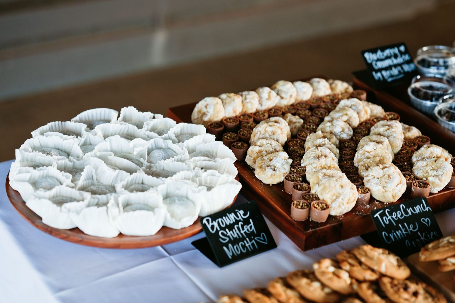 Dessert table display with brownie stuffed mints and toffee crunch treats arranged on wooden boards at a catered event.
